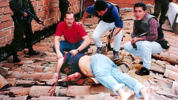 Steve Murphy with the body of Pablo Escobar after he was shot dead on a rooftop in 1993. 