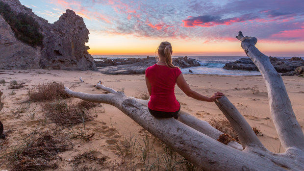 Landscape photographer Leah-Anne Thompson watches the sunrise at Queen Victoria Rock, near Narooma 