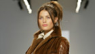 A model walks a New York catwalk wearing a mink coat with leather sleeves in 2005.