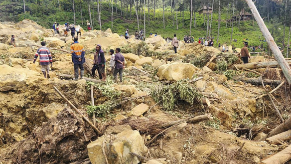Villagers search landslide debris in the village of Yambali, PNG.