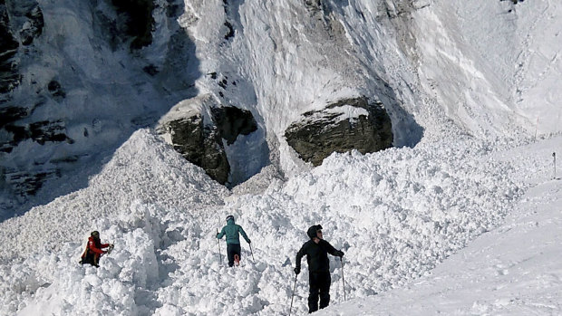 Rescue crews work work at the site of an avalanche site in the ski resort of Crans-Montana, Switzerland.