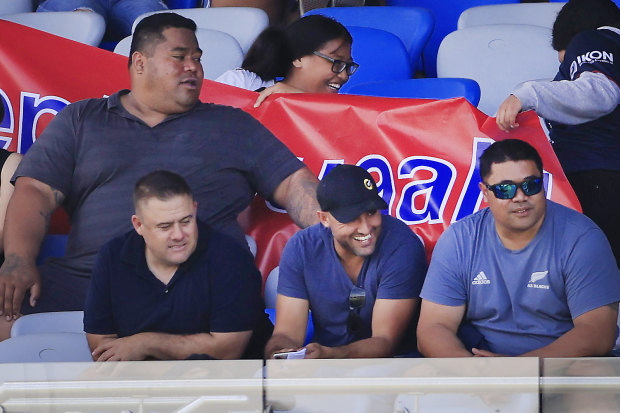 Deregistered player agent Isaac Moses (in blue shirt and black cap) sitting with the Suaalii family last month.