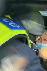A screenshot of Natalie Bonett's video, where police are seen removing her from her car at a Wallan checkpoint. 