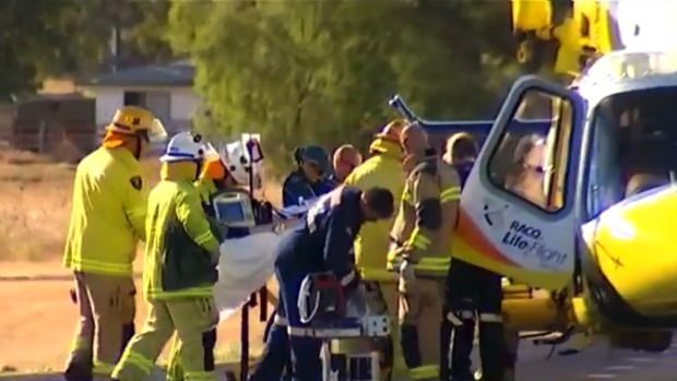 Paramedics treat a woman who was impaled in an accident on the Warrego Highway.