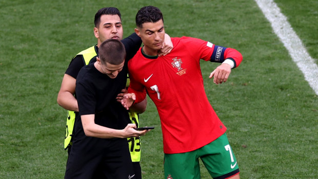 Fans seeking selfies with Ronaldo stop game six times as ‘slapstick’ own goal helps Portugal win