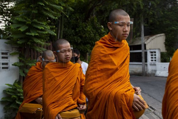 Buddhist monks wear face shields while collecting alms during a partial lockdown imposed due to the coronavirus in Bangkok, Thailand, on Monday, May 11.