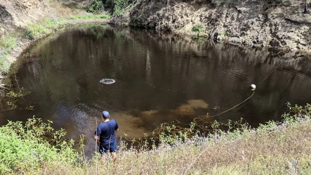 Police search one of the smaller dams in the area.