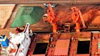 Quay cranes load iron ore off a ship at a port in Qingdao, Shandong province, eastern China in November.