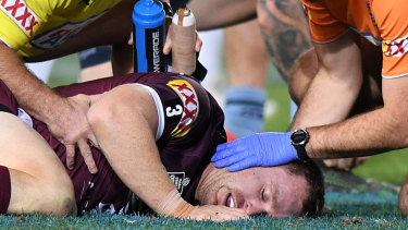 Michael Morgan with Maroons staff after taking a heavy blow to the head in Origin III.