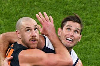 Shane Mumford and Tom Hawkins wrestle for the ball.