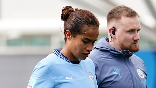 Mary Fowler leaves the field with a Man City trainer.