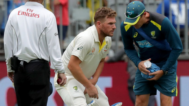 Cruel blow: Aaron Finch receives treatment on his injured finger before retiring hurt.