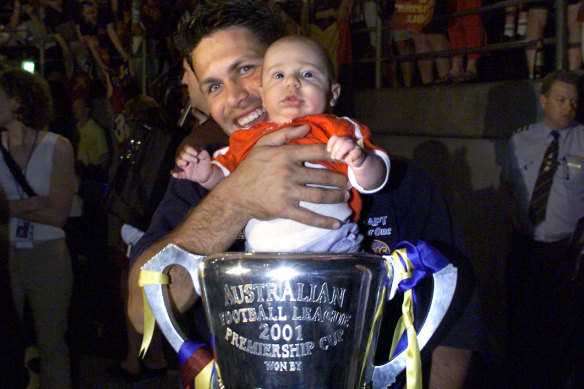 Chris Johnson with son Lachlan, pictured after the 2001 AFL grand final.