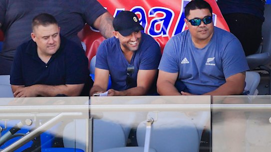 Deregistered player agent Isaac Moses (in blue shirt and black cap) sitting with the Suaalii family on Saturday.