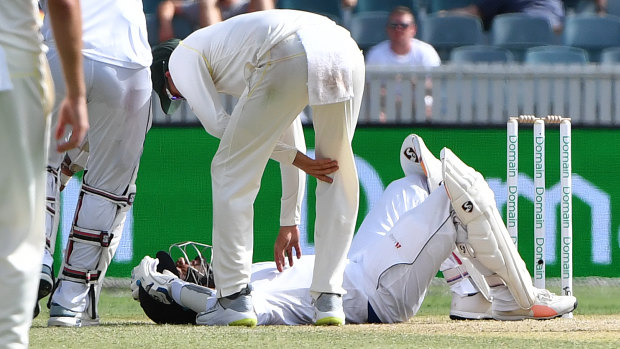 Man down: Sri Lankan batsman Dimuth Karunaratne on the ground after being hit in the head against Australia at Manuka Oval in February.