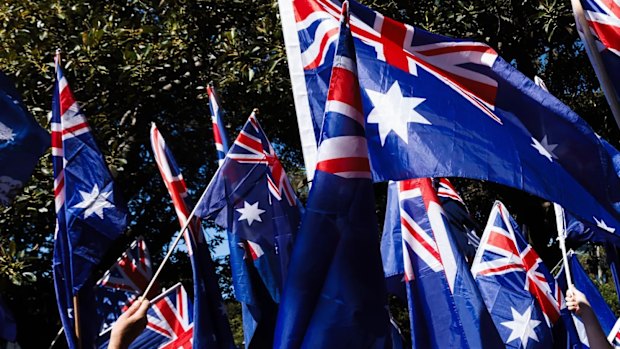 Protesters wave flags as they march against immigration in Sydney on Sunday.
