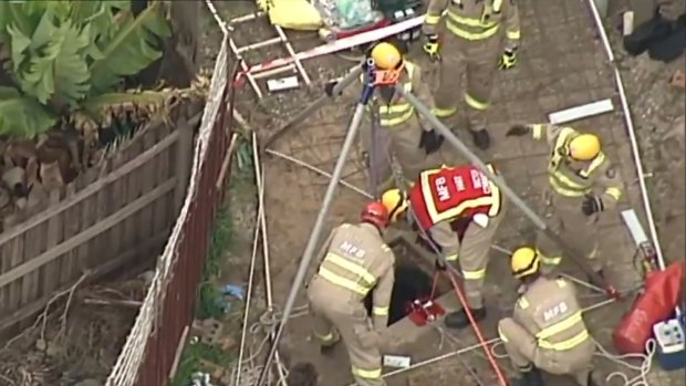 Crews are working to free a man trapped in a sewage drain.