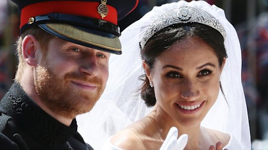 Prince Harry and Meghan Markle ride in an open-topped carriage through Windsor Castle.