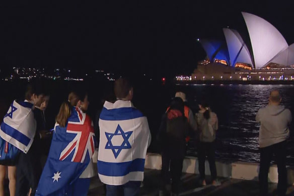 Warned off by police from attending the Sydney Opera House, supporters of Israel watched from afar on Monday night as it was lit up in blue and white. Pro-Palestinian protesters, meanwhile, filled the Opera House forecourt.