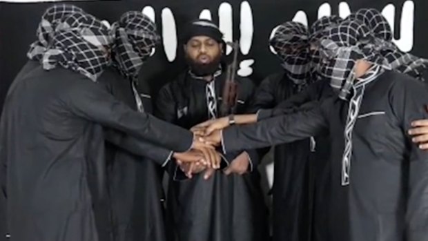 Image posted by Islamic State purports to show attackers in Sri Lanka standing before the terror group's flag. 
