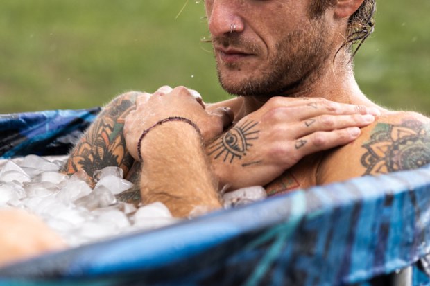 Athlete relaxing in a portable ice bath outside.