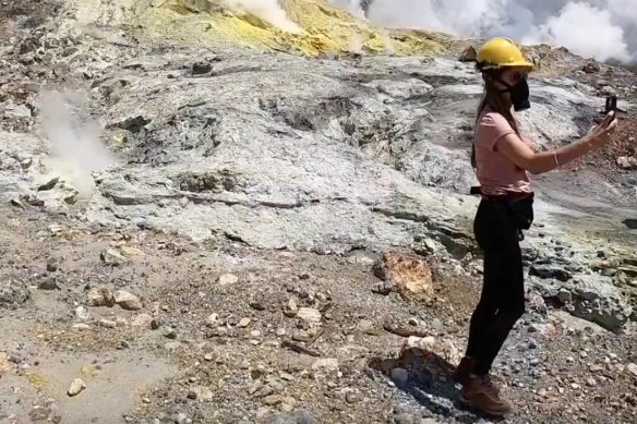 A tourist takes a selfie near the White Island crater lake.
