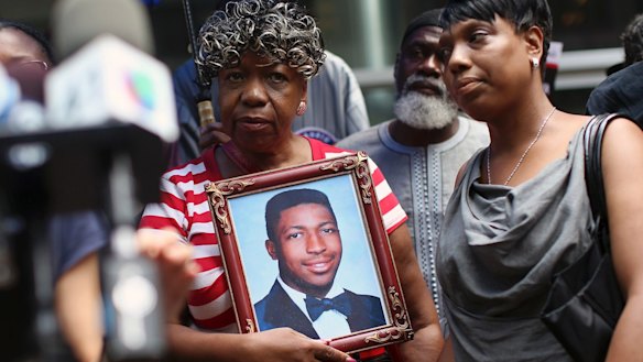 Gwen Carr, mother of Eric Garner, holds a photo of him during a news conference in 2015.