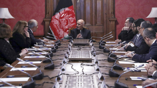 Afghan President Ashraf Ghani, centre, speaks to US peace envoy Zalmay Khalilzad, third left, at the presidential palace in Kabul on Monday.