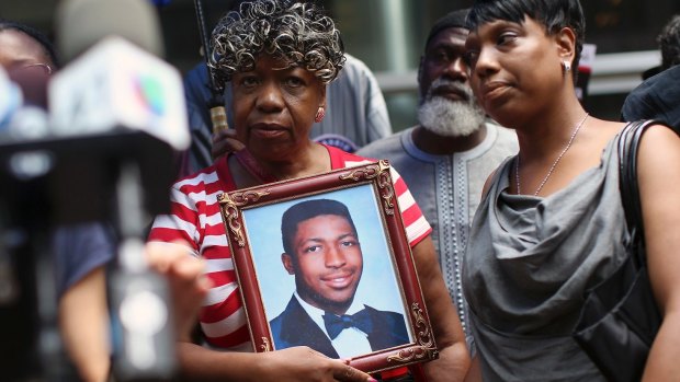 Gwen Carr, mother of Eric Garner, holds a photo of him during a news conference in 2015.