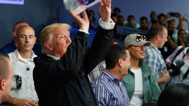 President Donald Trump tosses paper towels into a crowd in Puerto Rico last year following Hurricane Maria.