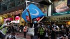 A protester displays a Uighur flag during a protest on China’s National Day in Causeway Bay.
