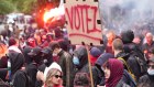 Protesters hold flares and banners during a demonstration against the far-right and racism in central Paris.