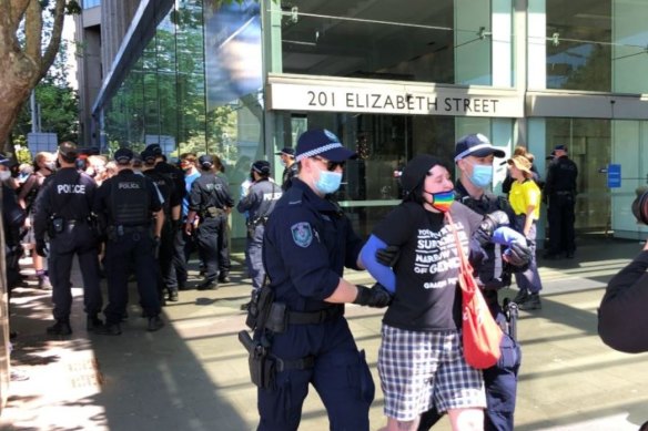 A protester is led away by police at a rally for transgender rights in Sydney. The event was prohibited by the NSW Supreme Court due to COVID-19 risk.