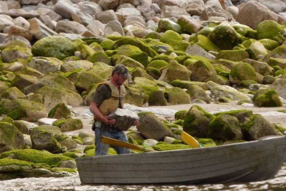 Locals photographed the men removing the 23 million-year-old fossil and loading it into a boat.