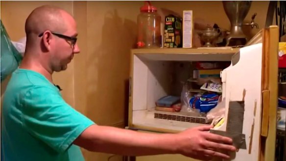 Adam Smith, 37, opens the freezer in his mother's St. Louis apartment. 