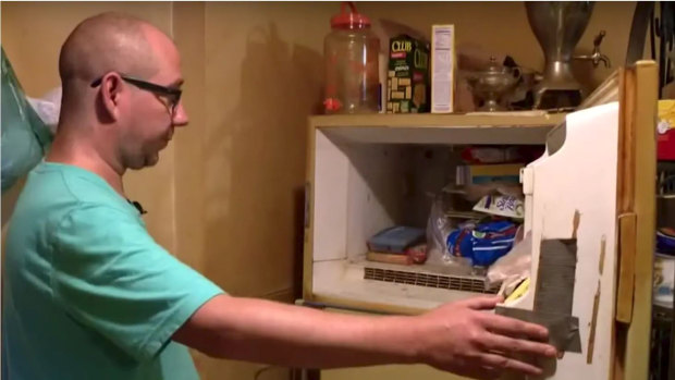 Adam Smith, 37, opens the freezer in his mother's St. Louis apartment. 