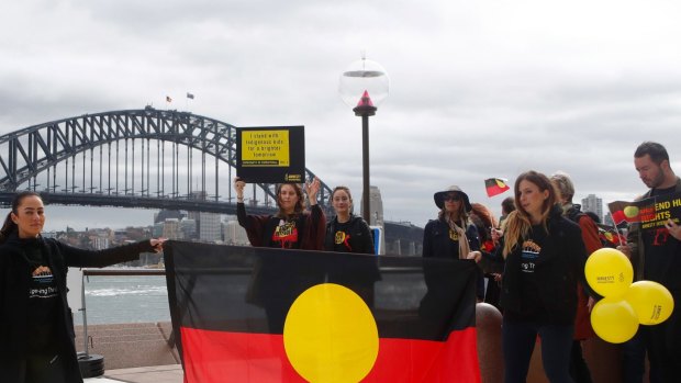 Cheree Toka and fellow demonstrators hold an Aboriginal flag during a demonstration in Sydney.