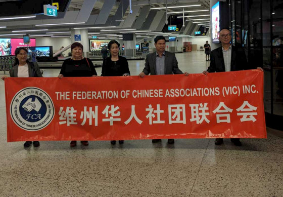 Members of the Chinese community wait at Melbourne Airport for the flight to arrive from Christmas Island.