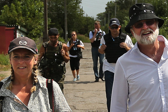 Sydney Morning Herald photographer Kate Geraghty (left) and former correspondent Paul McGeough (right) walk in front of an OSCE team and a pro-Russian rebel (second from left) along the streets of Rassypnoye in eastern Ukraine, where the cockpit of Malaysian flight MH17 crashed after being shot down on July 17, 2014.