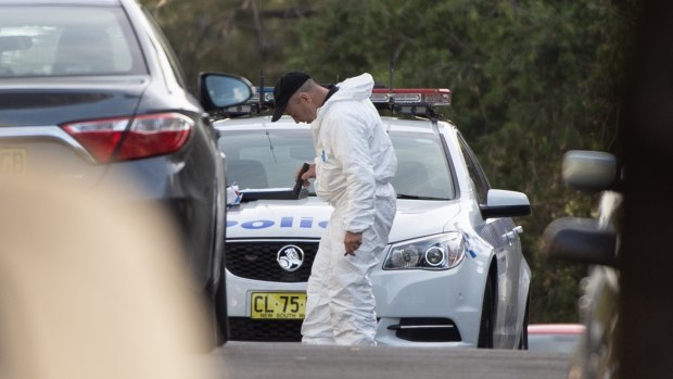 Police inspect a crime scene after Mr McKee was killed.