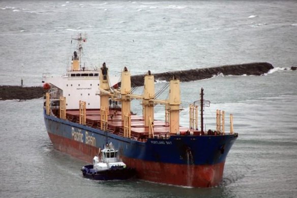 A tugboat aids the Portland Bay, a bulk carrier in danger of running aground off Wattamolla in July.