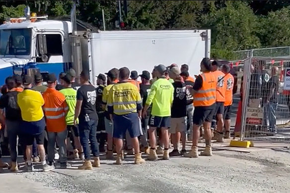 A crowd of about 30 to 40 men in CFMEU-branded clothing at the Centenary Bridge upgrade site on May 14.