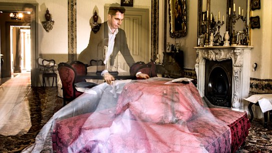 Adam Lindsay, executive director of Sydney Living Museums uncovering furniture which has been protected from dust and sunlight in the drawing room of Vaucluse House. 