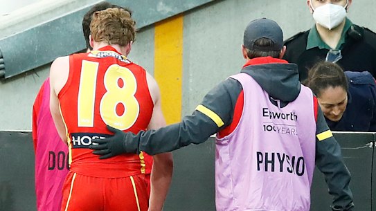 The youngster is escorted from the field.