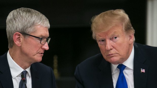 Tim Cook, CEO of Apple, speaks with US President Donald Trump. 