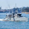 The unmanned surface vessel Sea Hunter transits underneath the Sydney Harbor bridge as part of an October training exercise. 