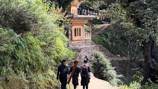 A classic Bhutanese structure featuring intricate wooden window frames and a tiered roof on the trail to the Tiger’s Nest Monastery.