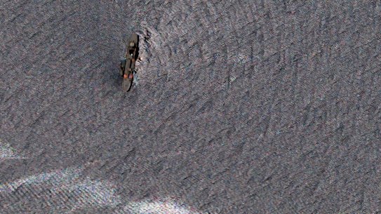 Oil-slicked waters spread out from the partially sunk Iranian navy vessel Kharg in the Gulf of Oman off the coast of Jask, Iran.