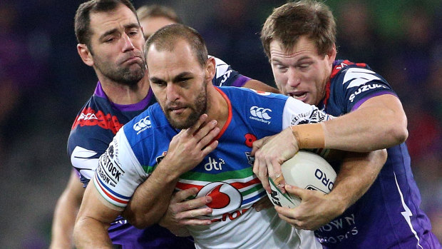 Tough night: Simon Mannering is tackled by a pack of Storm players.