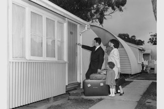 A migrant family enters their new home with hopeful faces in Maribyrnong, Victoria, 1965. Nissen huts were a normal feature of life in a 